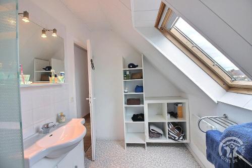 a bathroom with a sink and a toilet and a window at Glas ha gwenn in Plougrescant