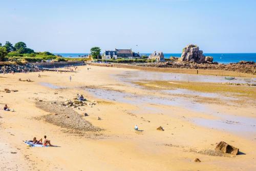a group of people on a beach near the ocean at Glas ha gwenn in Plougrescant