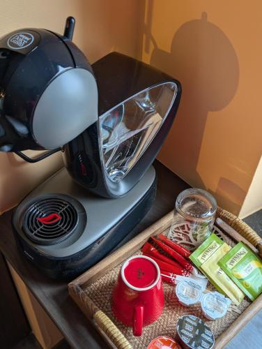 a coffee maker sitting on a table with food at A Fleur de Couette in Auvelais
