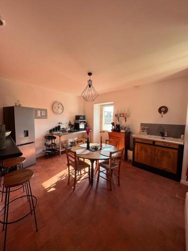 une cuisine et une salle à manger avec une table et des chaises dans l'établissement La Casa del Rio, à Durtal