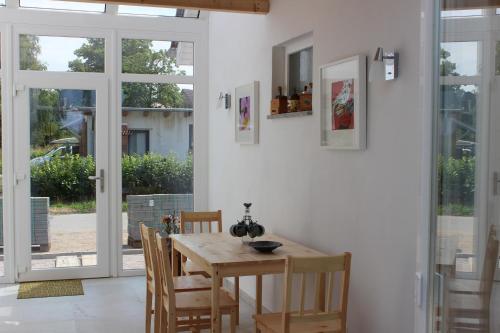 a dining room with a wooden table and chairs at Ostseepension TonArt in Mechelsdorf