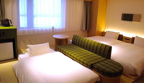 a hotel room with two beds and a couch at HOTEL AMANEK HidaTakayama in Takayama