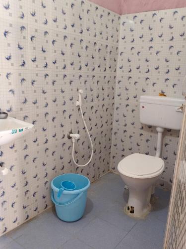 a bathroom with a toilet and a bucket in it at RS Homestay Puri in Puri