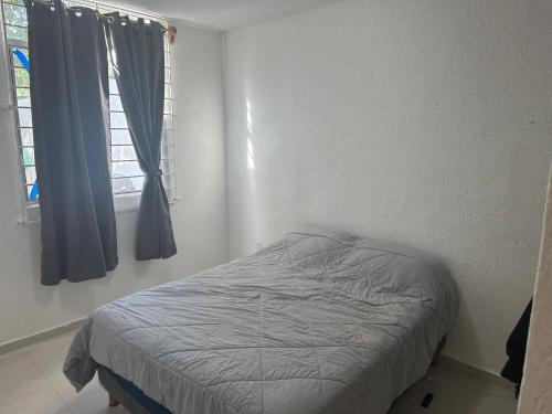 プエルト・モレロスにあるParadise awaits in this Seaside Escapeの窓付きの白い部屋のベッド1台