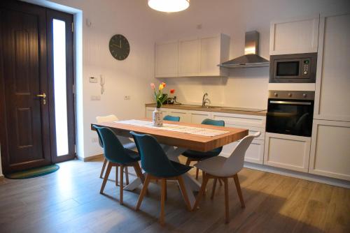 a kitchen with a wooden table and blue chairs at Dimora Maseva - DIEMME STAY in Alberobello