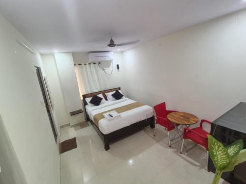a bedroom with a bed and a table and chairs at Vizag's DESTINY INN in Visakhapatnam