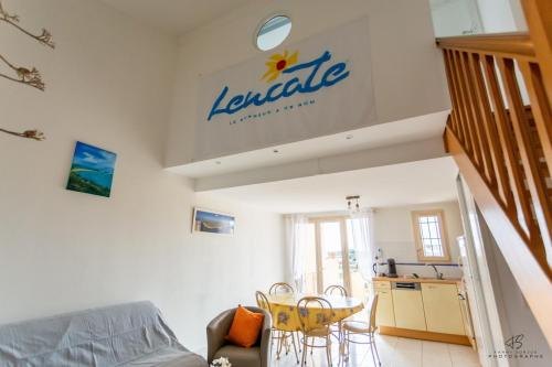 a living room with a table and a kitchen at Le Reflet du Canigou - Leucate - Vue , Terrasses , Parking in Leucate