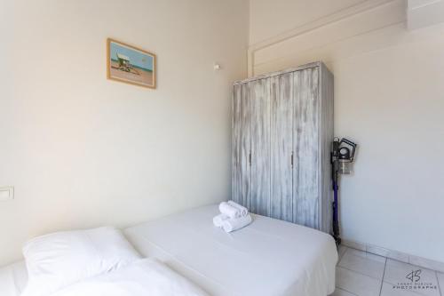 a room with two beds and a wooden door at Le Reflet du Canigou - Leucate - Vue , Terrasses , Parking in Leucate