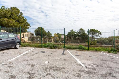 a car parked in a parking lot next to a fence at Le Reflet du Canigou - Leucate - Vue , Terrasses , Parking in Leucate