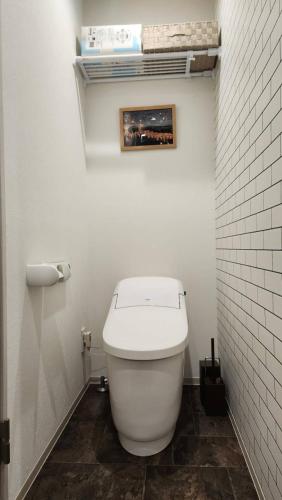 a bathroom with a white toilet in a white wall at 金澤屋Hirooka in Kanazawa