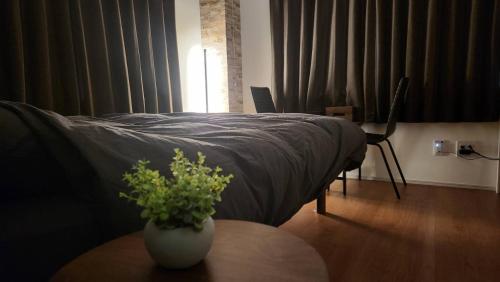 a bedroom with a bed and a vase with a plant on a table at 金澤屋Hirooka in Kanazawa