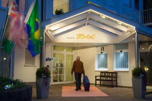 a man walking in front of a building at Hotel Engbert in Oelde