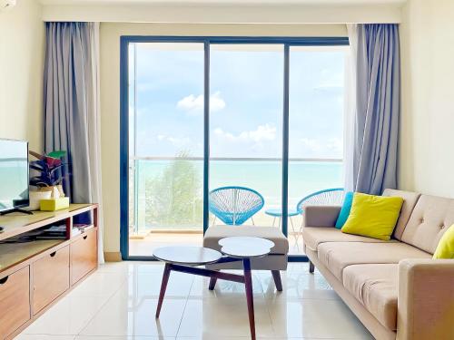 a living room with a couch and a view of the ocean at TimurBay Seafront Residence Kuantan in Kuantan