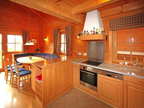 a kitchen with wooden cabinets and a island with a table at Chalet in Königsleiten near Hohe Tauern in Königsleiten