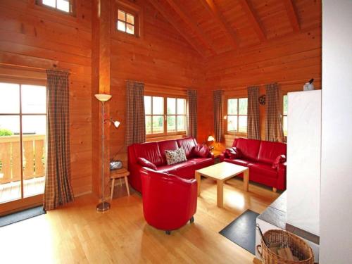 a living room with red furniture in a log cabin at Chalet in Königsleiten near Hohe Tauern in Königsleiten