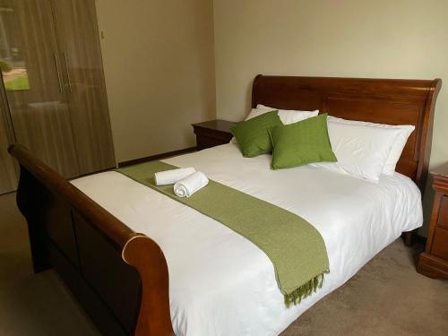 Cama con sábanas y almohadas verdes y blancas en Bridgelamour Guest house1, en Hartbeespoort