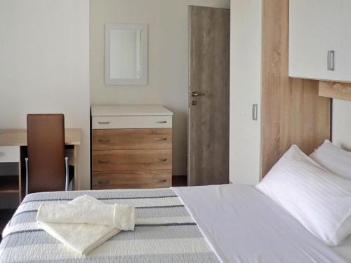 a bedroom with a bed with a table and a desk at Holiday Home Maslenica with Pool near Beach in Maslenica