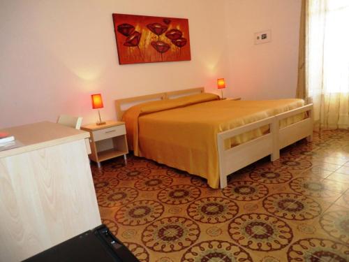 a bedroom with a bed and a table with two lamps at B&B Oasi in Marina di Palma