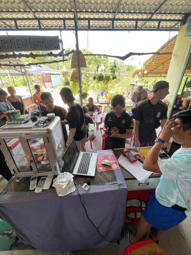 a group of people standing around a table with a laptop at Top View Kohrong in Koh Rong