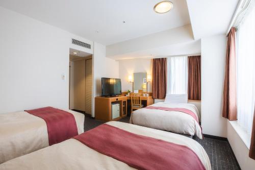 a hotel room with two beds and a television at Tokyo Bay Ariake Washington Hotel in Tokyo
