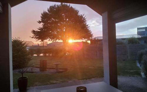 a view of the sunset from a window of a yard at Titoki House - Bed and Breakfast in Cambridge
