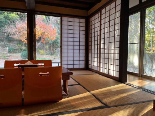 a room with windows and a table and chairs at 甘糟屋敷 Amakasu Yashiki KAMAKURA in Kamakura