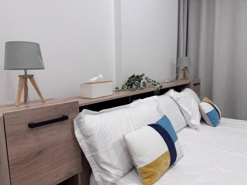 a bedroom with a bed with pillows and a desk at Appartement 2 chambres in Libreville