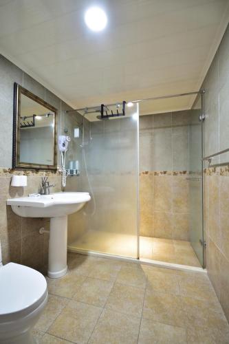 a bathroom with a shower and a toilet and a sink at Ji Li Ya Lan Homestay in Chenggong
