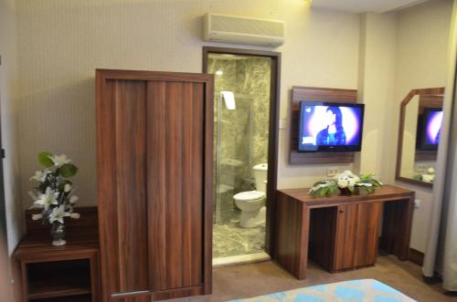 a bathroom with a toilet and a tv and a shower at Ayintap Hotel in Gaziantep