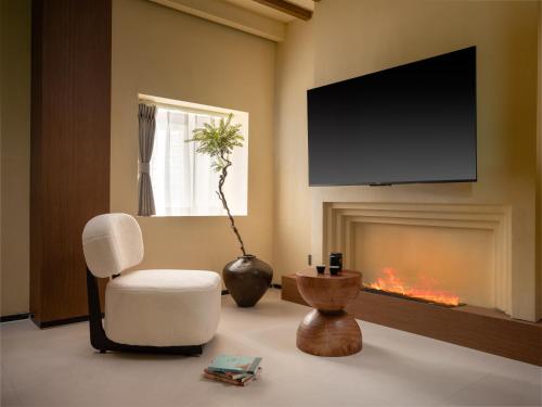 a living room with a chair and a fireplace at 半渡供氧Holiday Villa设计师民宿 in Shangri-La