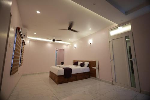 a bedroom with a bed and a ceiling fan at TTS Residency in Kaliyal