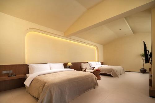 a hotel room with two beds and a large window at 半渡供氧Holiday Villa设计师民宿 in Shangri-La