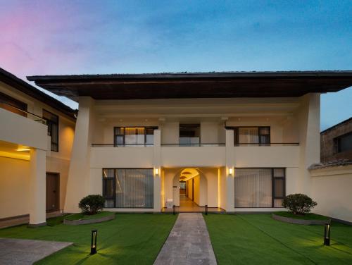 a house with a green lawn in front of it at 半渡供氧Holiday Villa设计师民宿 in Shangri-La