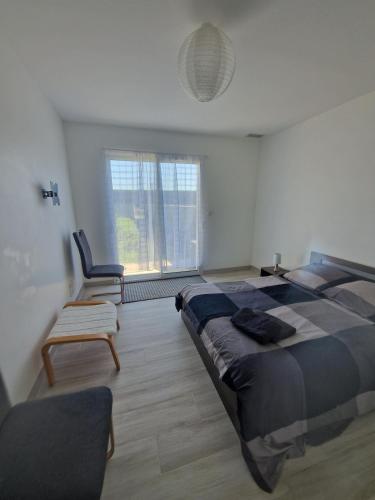 une chambre avec un lit, une chaise et une fenêtre dans l'établissement Maison 2 caroline, à Cadaujac