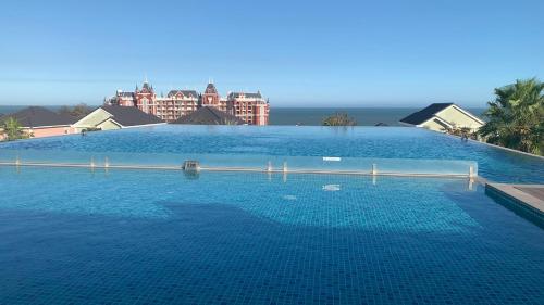 a large pool of blue water with buildings in the background at Novaworld Phan Thiết - Ako Villa in Bình Tú