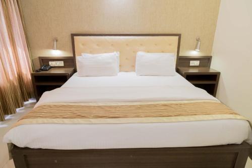 a bedroom with a large bed with two night stands at Hotel Aroma Executive Panaji -Stay in the Heart of the City in Panaji