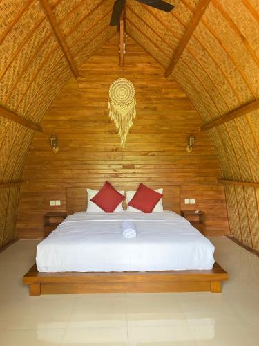 a bedroom with a white bed with a wooden wall at Made Misi Homestay & Guesthouse in Penginyahan