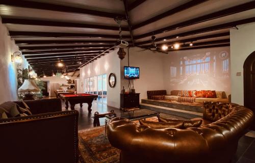 a living room with a leather couch and a pool table at Villa Sajuri Homestay Sg Sembilang in Jeram