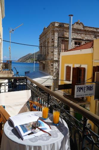 a table on a balcony with a view of the water at Antoni's Symi Home in Symi