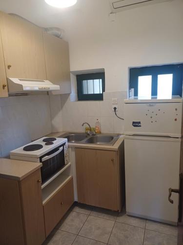 a small kitchen with a stove and a sink at Floisvos Apartments in Selianitika