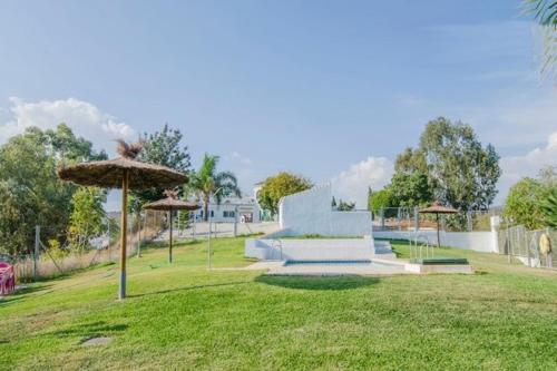un parque con banco y sombrilla en Finca Buenavista, en Chilches