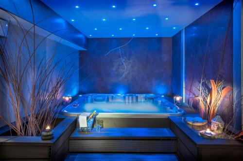 ein Badezimmer mit einer Badewanne mit blauer Beleuchtung in der Unterkunft Logis Hotel Restaurant Family & Spa in Meyrueis