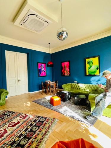 a man sitting on a couch in a living room at Communa Good Vibes in Tbilisi City