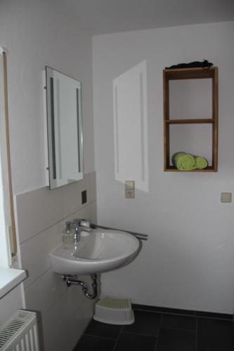 a white bathroom with a sink and a mirror at Pension Boitz in Rust