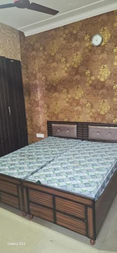 a bed in a room with a wall at City heart in Kharar