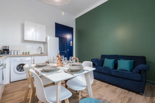 un salon avec une table et un canapé bleu dans l'établissement Noa house, à Nice
