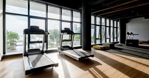 a gym with two treadmills in a room with windows at TimurBay Seafront Residence Kuantan in Kuantan