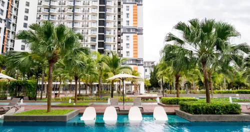 a swimming pool with palm trees and buildings at TimurBay Seafront Residence Kuantan in Kuantan
