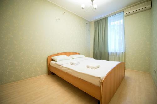 車里雅賓斯克的住宿－Five Stars on Timiryazeva 29，一间卧室配有一张带白色床单的床和一扇窗户。