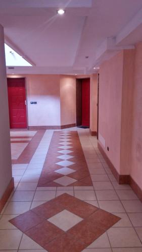 an empty room with red doors and a tile floor at Aparthotel Capitol in Grado